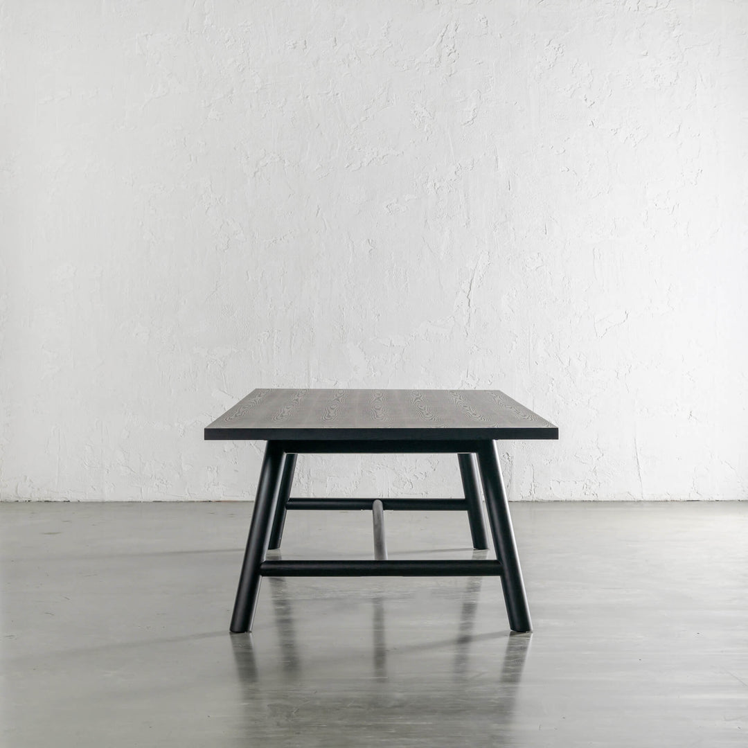 NOMA TRESTLE DINING TABLE END VIEW  |  BLACK NOIR WOOD GRAIN 