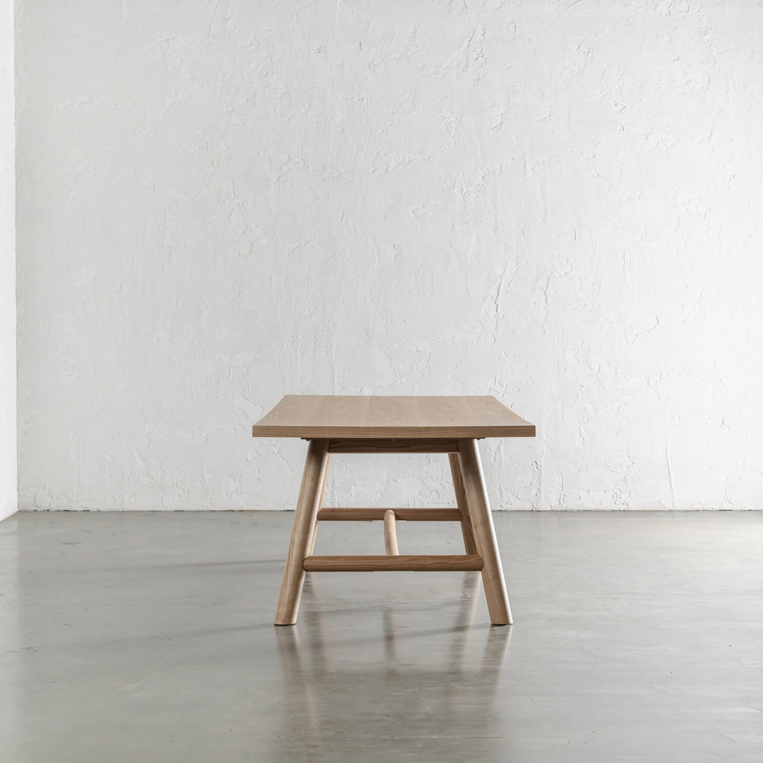 NOMA TRESTLE DINING TABLE END VIEW  |  BIRCH ASH WOOD GRAIN 